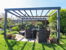 A garden with a seating area under a pergola at 3 Rock Cottages Kingston
