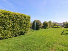 A garden with grass and hedges at 3 Rock Cottages Kingston