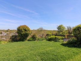 A garden with grass, bushes and flowers at 3 Rock Cottages Kingston