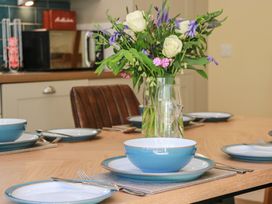 A dining table set with plates and flowers at Ardlochan Lodge - Culzean Castle Maybole