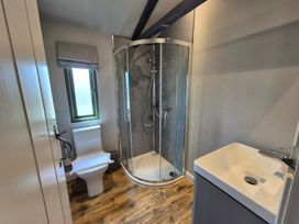 A bathroom with a shower, toilet, and wash basin at Birch Banc Retreats - Bedw Llanidloes