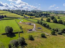 An aerial view of fields and cabins at Birch Banc Retreats - Bedw in Llanidloes