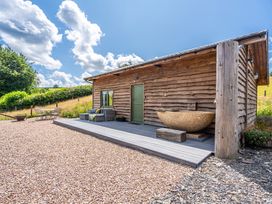 An outdoor view of a wooden building with a deck at Birch Banc Retreats - Bedw Llanidloes