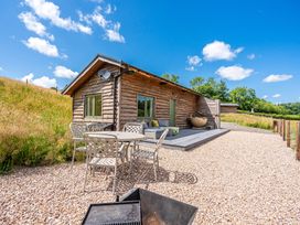 A wooden cabin with a table and chairs at Birch Banc Retreats - Bedw, Llanidloes