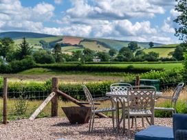 An outdoor seating area with a table and chairs at Birch Banc Retreats - Bedw in Llanidloes