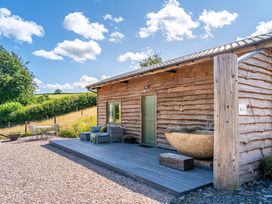 An outdoor area with a wooden hut and seating at Birch Banc Retreats - Bedw Llanidloes