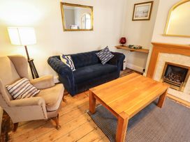 A living room with a blue sofa and wooden coffee table at Maples in Hunstanton