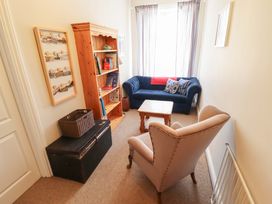 A snug with a sofa and bookshelf at Maples in Hunstanton