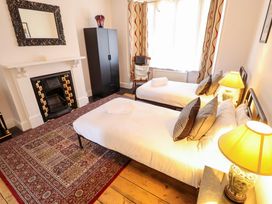 A bedroom with two beds and a fireplace at Maples in Hunstanton