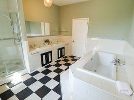 A bathroom with two sinks, a shower, and a bathtub at Maples in Hunstanton