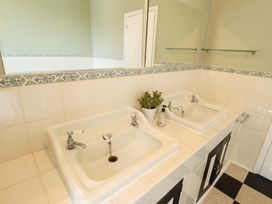 A bathroom with two sinks and a mirror at Maples in Hunstanton