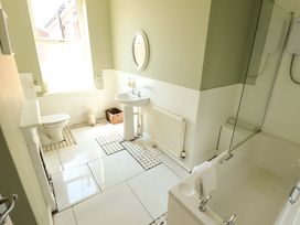 A bathroom with a sink, toilet, bathtub and shower at Maples in Hunstanton