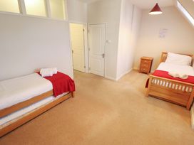 A bedroom with two beds and a nightstand at Maples in Hunstanton