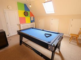 A game room with a pool table and dartboard at Maples in Hunstanton