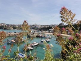 A harbor with boats in the water and buildings in the background at 49 Atlantic Reach in Newquay