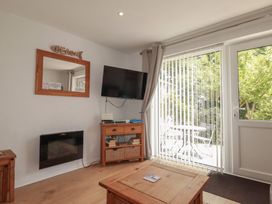 A living room with a television and sliding door at 49 Atlantic Reach in Newquay