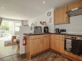 A kitchen with wooden cabinets and appliances at 49 Atlantic Reach in Newquay