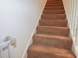 A staircase with carpet stairs and a baby gate at 49 Atlantic Reach Newquay