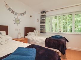 A bedroom with two beds and a window at 49 Atlantic Reach, Newquay