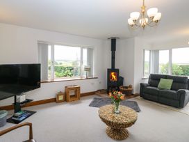 A living room with a fireplace and sofa at Sherriff, Troutbeck, near Keswick