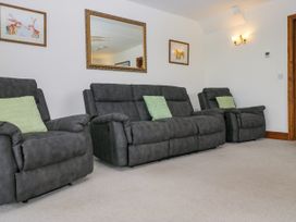 A living room with recliner sofas and a mirror at Sherriff, Troutbeck, near Keswick