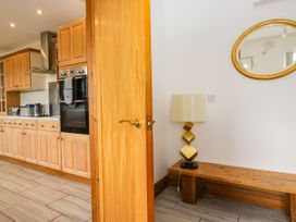 A kitchen with wooden cabinets and a lamp at Sherriff in Troutbeck, near Keswick