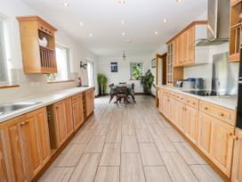A kitchen with wooden cabinets and a dining table at Sherriff, Troutbeck, near Keswick