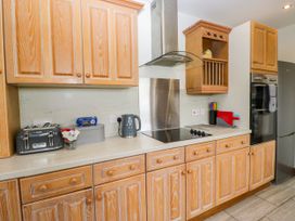 A kitchen with wooden cabinets, countertop, kettle, toaster, and fridge at Sherriff, Troutbeck, near Keswick