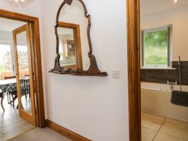 A hallway with a mirror and view into a bathroom at Sherriff, Troutbeck, near Keswick
