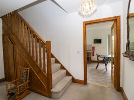 A hallway with a staircase and a rocking chair at Sherriff, Troutbeck, near Keswick