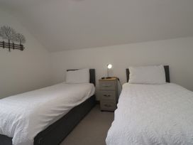 A bedroom with two single beds and a nightstand at Sherriff in Troutbeck, near Keswick