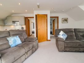 A living room with sofas and a door leading to the kitchen at Sherriff in Troutbeck, near Keswick