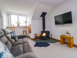 A living room with a stove and television at Sherriff, Troutbeck, near Keswick