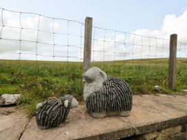 Two stone sheep statues near a fence at Sherriff in Troutbeck, near Keswick