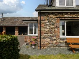 An outdoor view of a stone wall with plants and a bench at Sherriff, Troutbeck, near Keswick