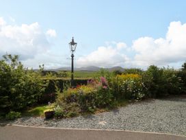 An outdoor view of a garden with flowers and a lamp post at Sherriff in Troutbeck, near Keswick
