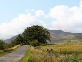 A rural scene with a road and tree near mountains at Sherriff, Troutbeck, near Keswick