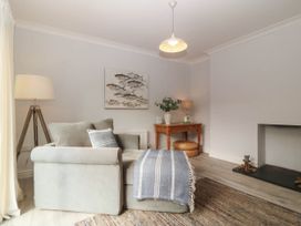 A living room with a chair and table with a lamp at Afallon in Llanbedrog