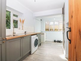 A kitchen with a washing machine and sink at Afallon in Llanbedrog