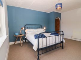 A bedroom with a bed and lamp at Afallon in Llanbedrog
