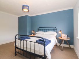 A bedroom with a bed and a decorative sign at Afallon in Llanbedrog