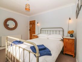 A bedroom with a bed and wooden furniture at Afallon in Llanbedrog