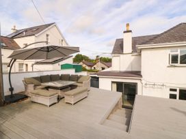An outdoor seating area with a table and umbrella at Afallon in Llanbedrog
