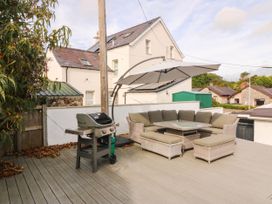 An outdoor seating area with a grill and table at Afallon in Llanbedrog