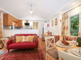 A living room with a dining area and kitchen in Orchard Lodge Bolney