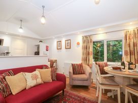 A living room with furniture and a dining area at Orchard Lodge Bolney