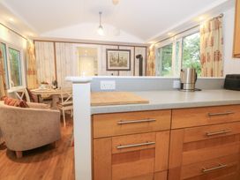 A kitchen with a dining area at Orchard Lodge Bolney