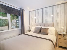 A bedroom with a bed and window at Orchard Lodge in Bolney