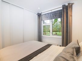 A bedroom with a bed and window at Orchard Lodge in Bolney