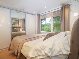 A bedroom with a bed and window at Orchard Lodge in Bolney